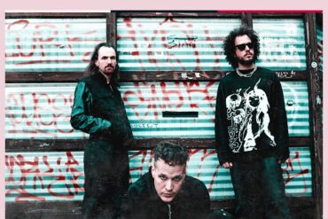 Bandfoto von Added Color vor einem Graffiti-beschmierten Hintergrund.