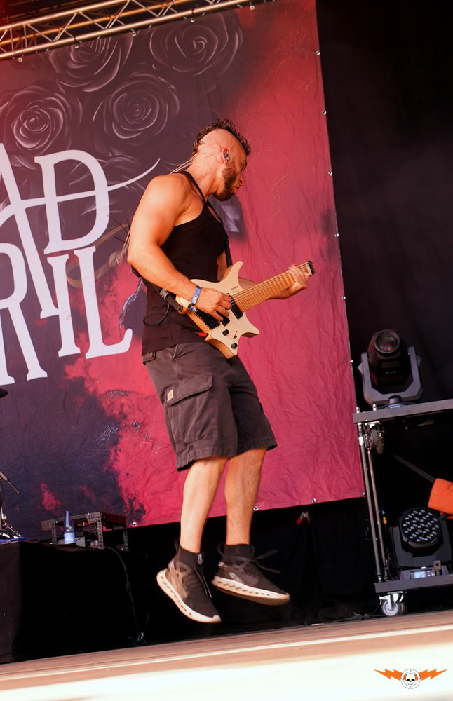 Metal Gitarrist auf Bühne bei Time For Metal mit rotem Hintergrund.