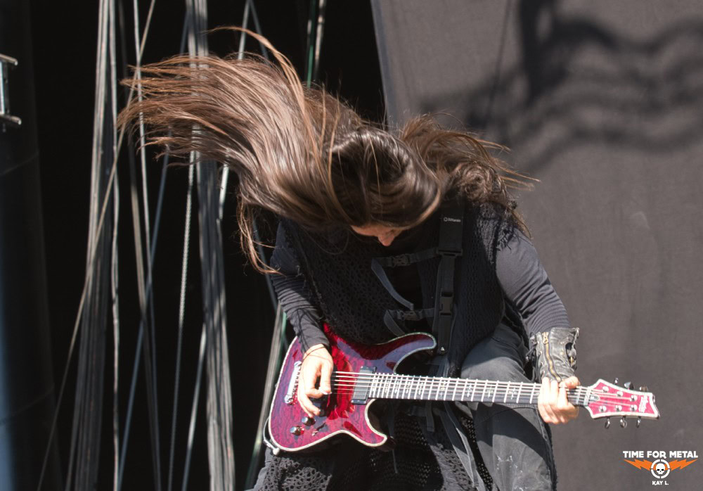 Metal-Gitarristin mit langem Haar beim Auftritt auf der Bühne.