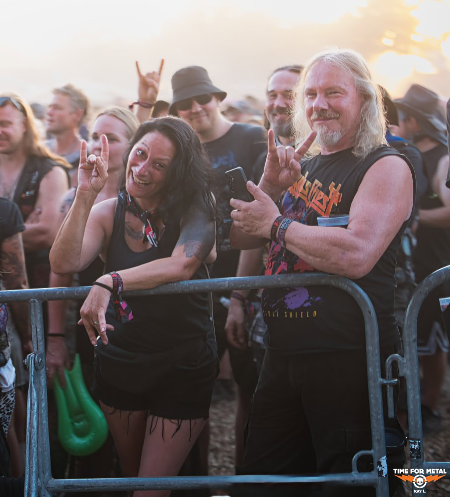 Freudige Metal-Fans beim Live-Konzert, zeigen das Hornzeichen, genießen die Musik.
