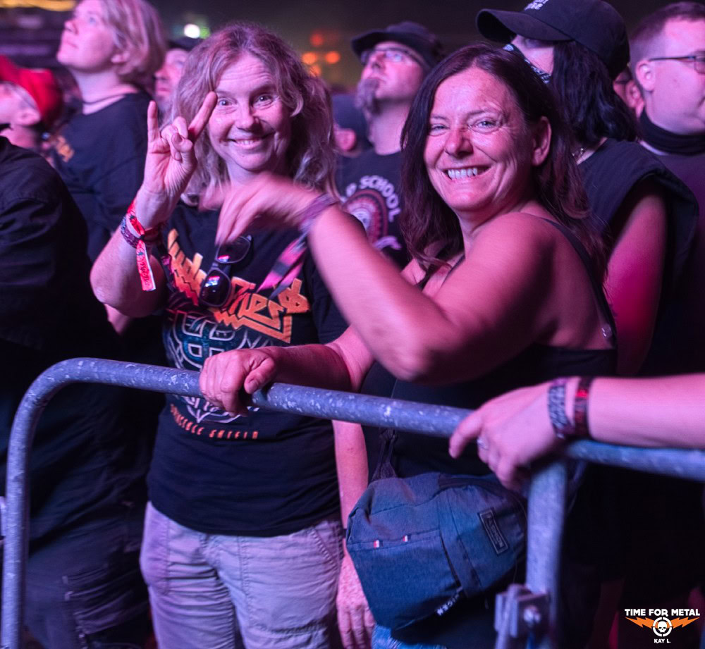 Zwei Frauen beim Metal-Konzert, feiern und posieren für Foto.